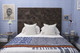 Held Over Water quilt, 200cm x 200cm, draped over a bed with a wooden headboard in a blue bedroom, styled with We Sailed Away wallpaper and matching cushions in a Fogo Island interior.